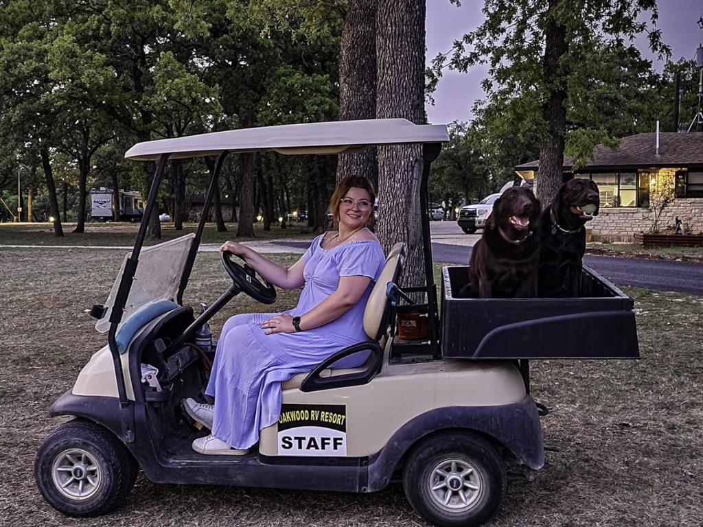 woman and dogs riding golf cart