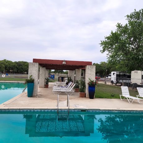 An inviting view of the resort's Olympic-sized swimming pool, emphasizing the relaxation and cooling off options available during hot Texas summers at Oakwood RV Resort in Fredericksburg, TX.