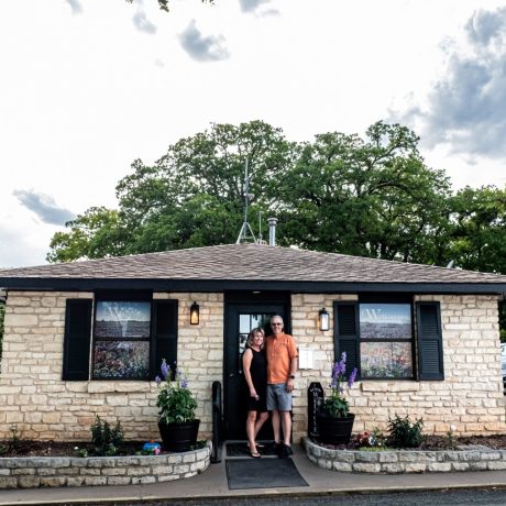 A happy family at Oakwood RV Resort in Fredericksburg, TX, surrounded by beautiful shady views and rustic charm.